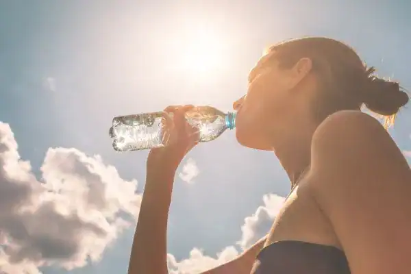 Hydration: The Secret Ingredient for a Toned Stomach and Enhanced Fitness 3 Image of woman drinking water to hydrate Bracknell after run.